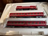 three red and black trains sitting on top of a white tray