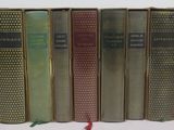 several books are lined up in a row on a white surface