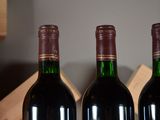 three bottles of red wine sitting on a table
