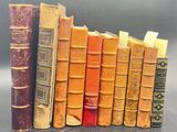 several old books are lined up in a row on a table