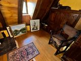 a room with a chair, a rug, and pictures on the floor