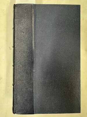 un livre noir posé sur une table blanche