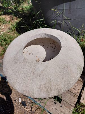 a concrete bowl sitting on a pallet next to a building