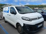une camionnette blanche garée dans un parking à côté d'autres voitures