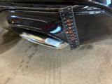 a close up of a black car with a measuring tape on it ' s bumper