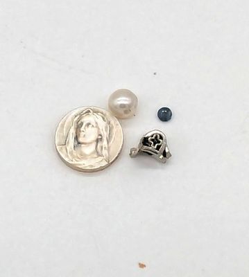 une image représentant une pièce de monnaie et une petite perle sur un fond blanc