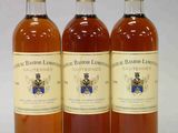 trois bouteilles de vin posées les unes à côté des autres sur une surface blanche