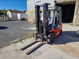 un chariot élévateur à fourche garé devant un bâtiment