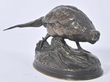 bronze statue of a bird on a rock on a white background