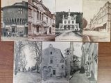 several old postcards of old buildings on a wooden table