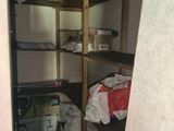 a small room with shelves and a stove in it