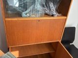 a wooden cabinet with a glass door in a room