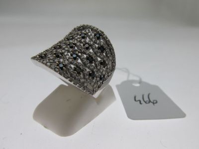 bague en argent sertie de diamants noirs et blancs sur un fond blanc