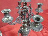 a silver candelab that is sitting on a red cloth