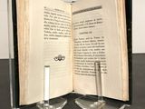a open book on a table with a candle on it