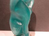 une sculpture en verre représentant le visage d'une femme, posée sur un socle
