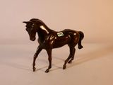 un cheval brun qui se tient debout sur une surface blanche
