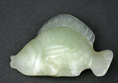 une image représentant un poisson sculpté sur une surface noire