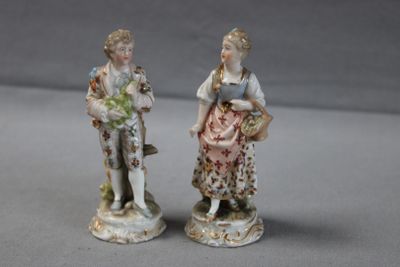 deux figurines représentant une femme et un homme debout l'un à côté de l'autre