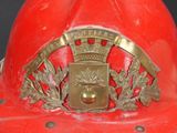 a red fireman ' s helmet with a gold crown on it