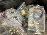 many bags of christmas ornaments in a bin on the table