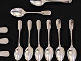 six spoons and six spoons sitting on a table