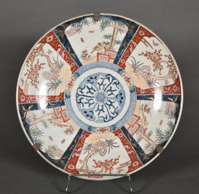 une photo représentant une assiette décorative posée sur un socle, sur une table