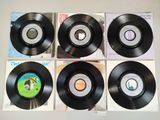 four black vinyl records sitting on top of each other on top of a table