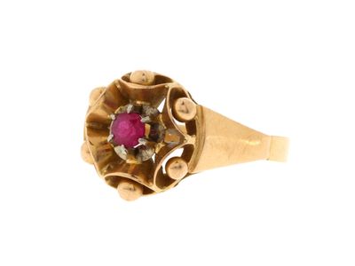gros plan d'une bague en or avec une pierre en rubis