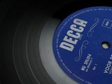 vinyl record with a blue label on it sitting on a table