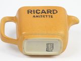 a yellow mug that has a black and white logo on it