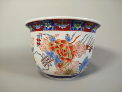 un vase blanc orné d'un motif rouge et bleu