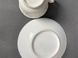 pair of white porcelain cups and saucers on a table
