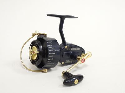 a black spinning reel with a gold handle on a white background