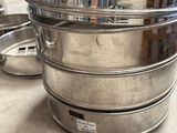 three stainless steel containers stacked on top of each other on a table