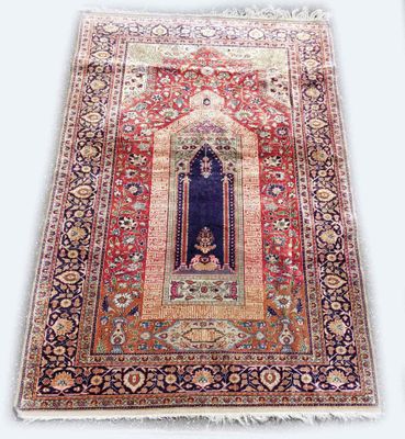 un tapis persan ancien représentant une femme dans une embrasure de porte