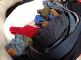 a pile of clothes in a basket on a bed