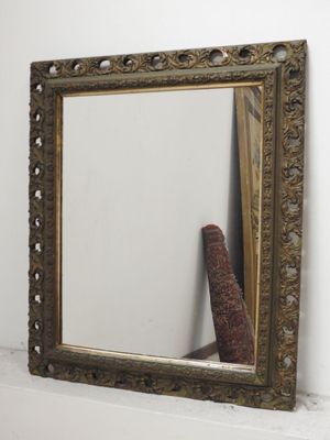 un miroir posé sur une étagère à côté d'un vase