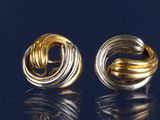 une paire de boucles d'oreilles en or et en argent sur un fond noir