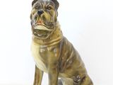 une figurine de chien assise sur une surface blanche