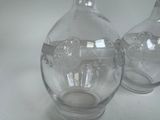 two clear glass vases sitting on a white table