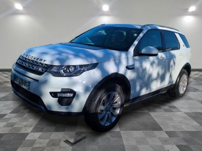 the white land rover is parked in a large room