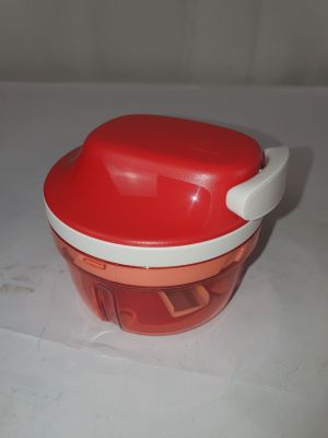 un saladier rouge et blanc avec un couvercle, posé sur une table blanche