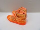 a pair of orange shoes that are on a table