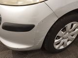 a white car that has a dent in the front of it
