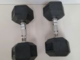 pair of black rubber dumbbells on a white surface