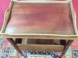 a small wooden table with a glass top on a rug