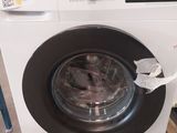 une machine à laver posée sur une palette dans un entrepôt