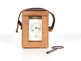 une petite horloge posée à côté d'une paire de ciseaux