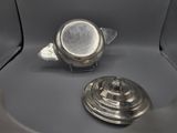 a silver tea pot and a silver teapot sitting on a table
